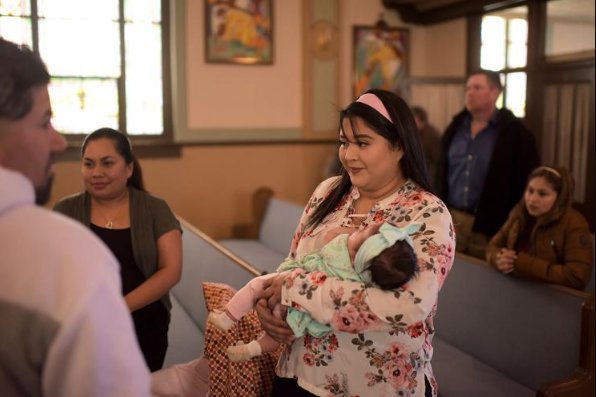 Maya Hernandez holds 2-month-old Nathalia Marriot, the daughter of a friend, after Easter Mass at St. Mary Church in Milan. The church has Sunday services in English, Spanish and French.